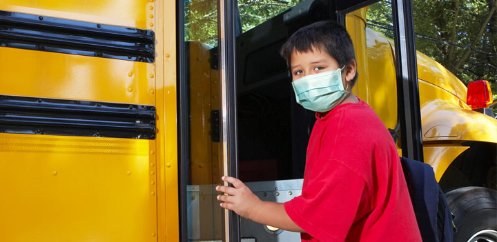 boy in mask on bus